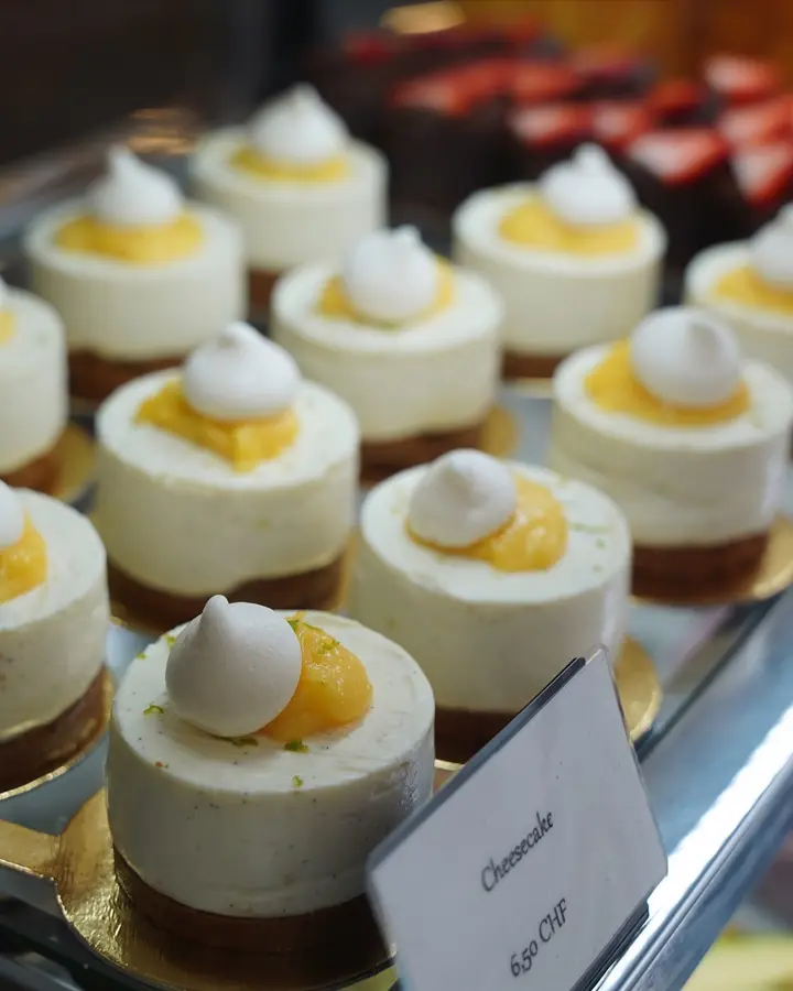 Kleine Cheesecakes mit Baiser-Tupfen in der Vitrine