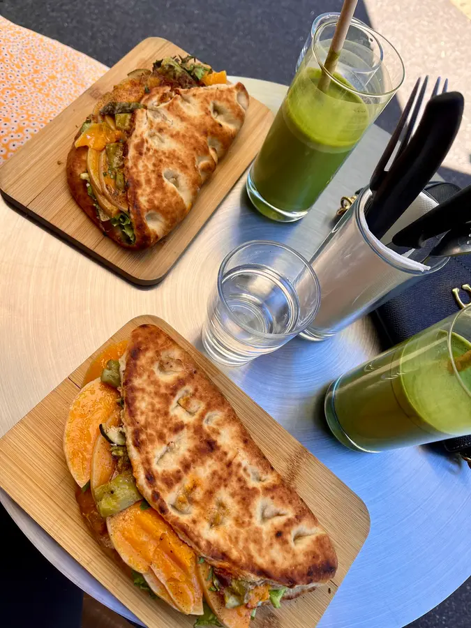 Focaccia-Sandwiches auf Bambusbrettern und grüne Drinks
